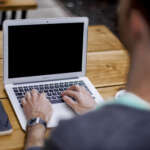How to Dodge Scams While Cheering on Ohio State in the National Championship Hands typing on a laptop keyboard