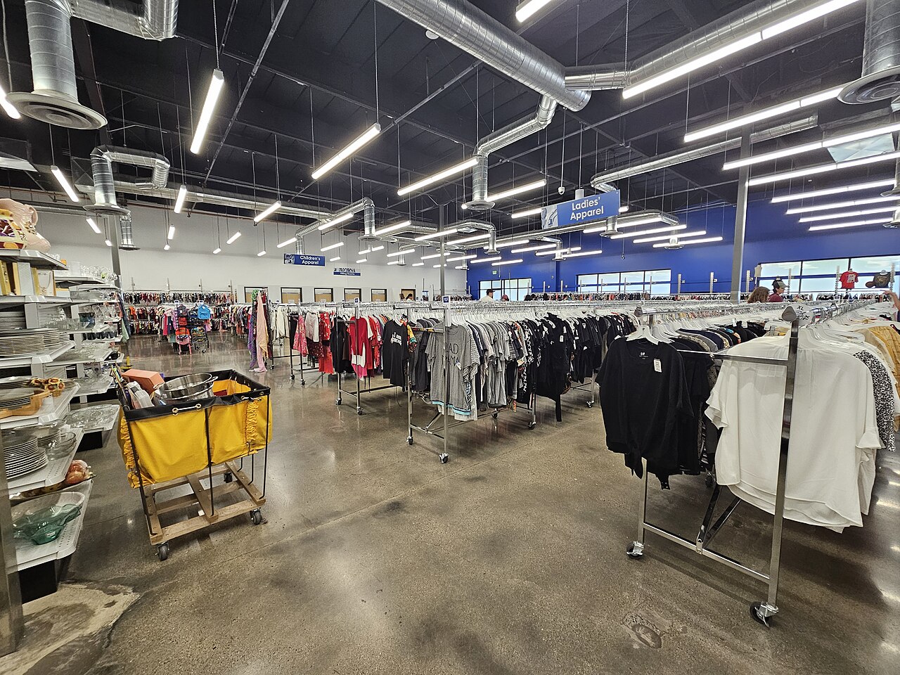 clothes hanging on racks in goodwill store