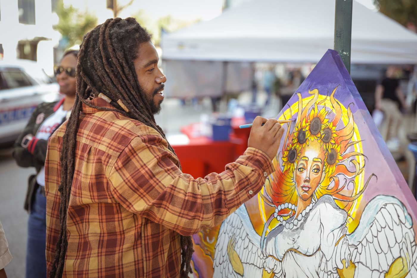 Spend Labor Day Weekend Exploring Art And More At September Gallery Hop 2 man painting canvas during street fair