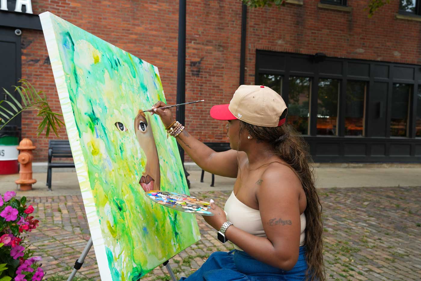 woman painting canvas during street fair