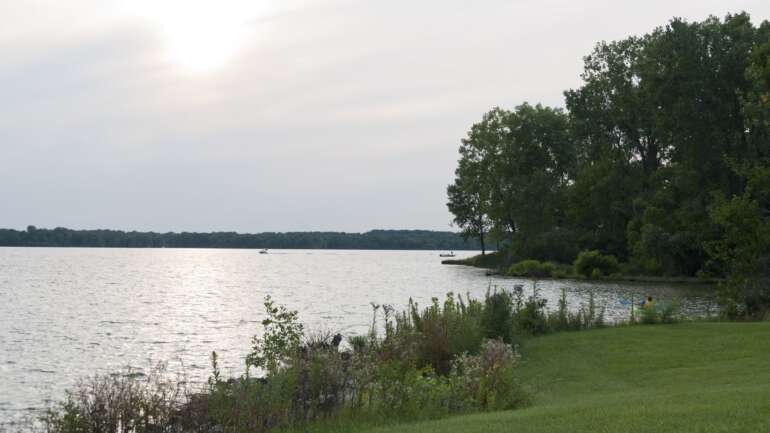 The Best Things To Do At Alum Creek State Park 2 Alum Creek Lake at Alum Creek State Park on a hazy summer evening, with a kayak near the shore and a boat crossing the water