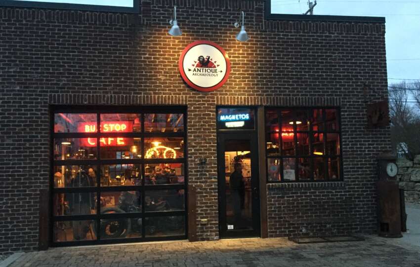 Brick storefront of Antique Archaeology, the American Pickers shop in LeClaire, Iowa, with neon signs lit at dusk