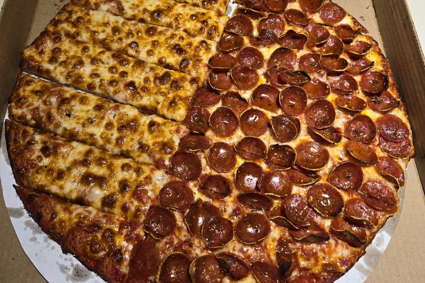Half cheese, half pepperoni Columbus-style pizza from Massey's, cut into rectangles, in a delivery box