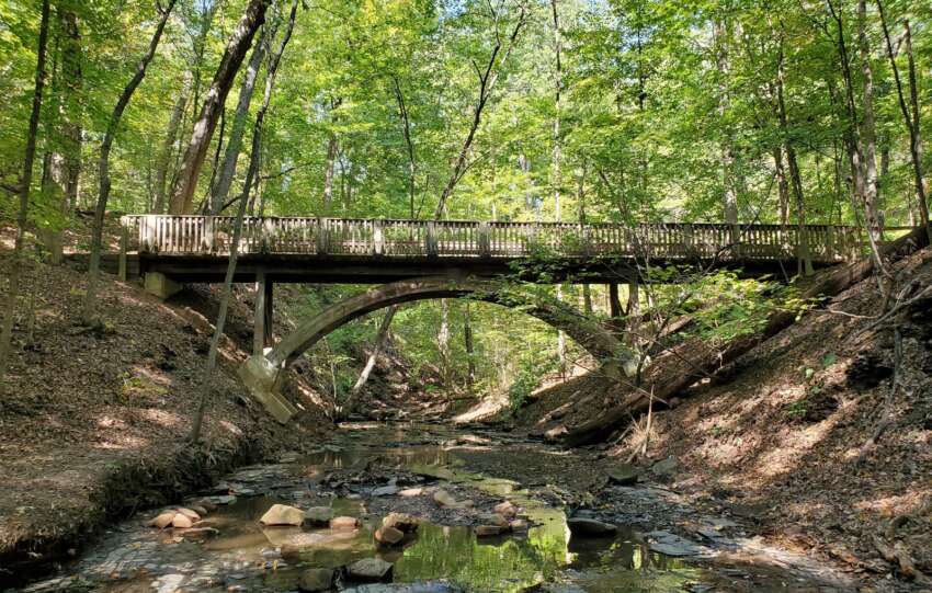 Stone arch bridge carrying the Dripping Rock Trail over a ravine at Highbanks Metro Park in early October
