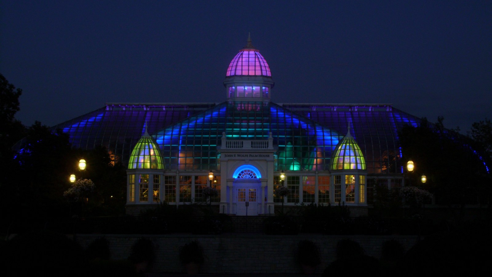 The Best Things To Do In Columbus This Weekend (October 9–11) 2 The glass Palm House at Franklin Park Conservatory lit purple, blue and green at night