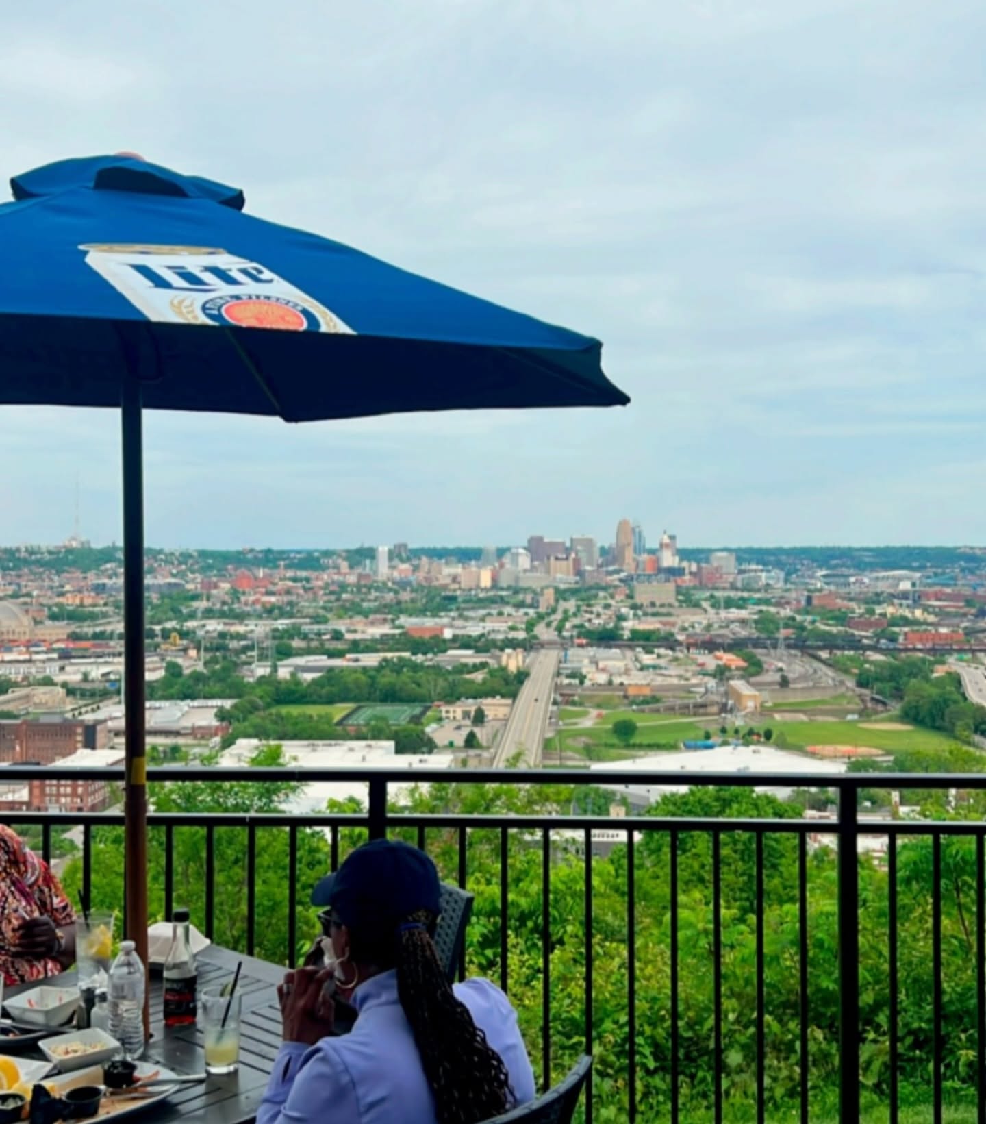 people sitting on patio overlooking Cincinnati in distance
